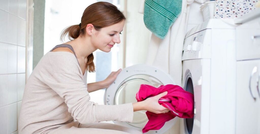 11 Ways to Make Laundry Day Easier | Laundry Care Woman putting laundry in an empty dryer