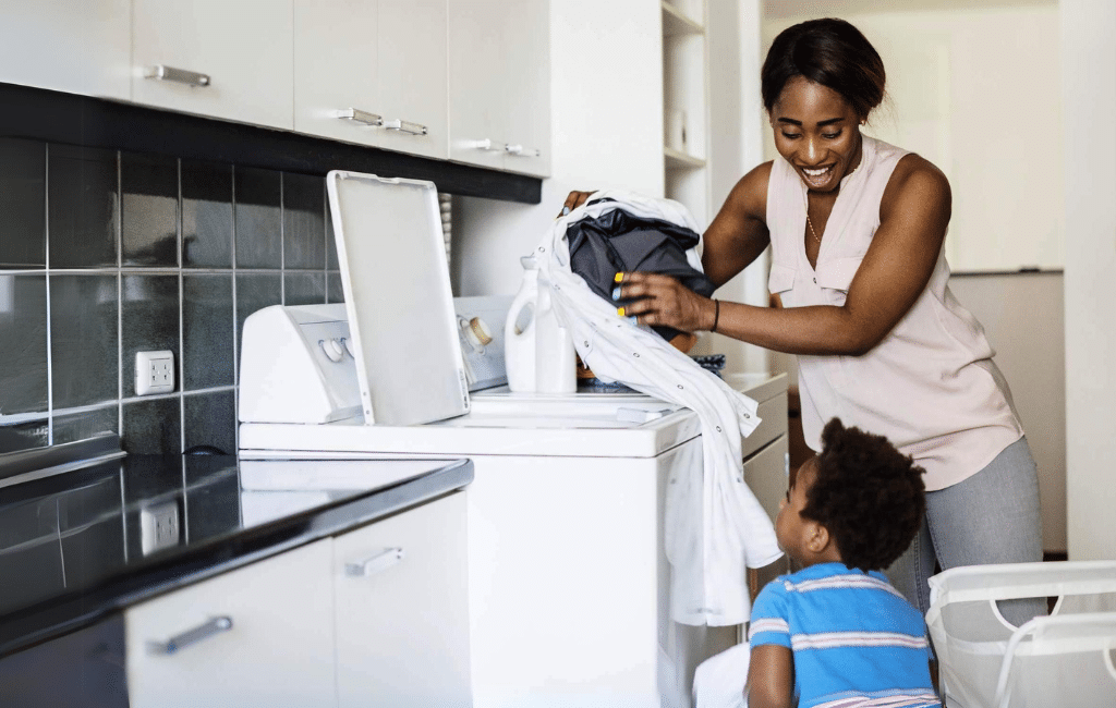 5 Simple Ways to Get Kids to Help with Laundry Today | Laundry Care happy mom loading the washer with dirty laundry helped by her young son